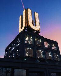 Low angle view of illuminated building against sky at dusk