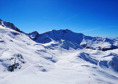 Scenic view of snowcapped mountains against clear blue sky