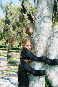 Woman standing on tree trunk