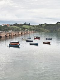 Boats moored in river against sky