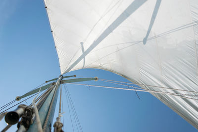 Low angle view of sailboat against clear blue sky