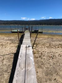 Wooden pier on lake against sky