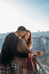 Young couple drinking coffee on the balcony of the apartment in the morning. young happy couple