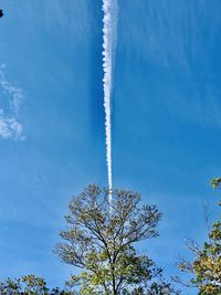 Low angle view of vapor trail against blue sky