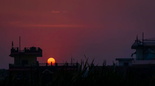 Silhouette building against sky at sunset