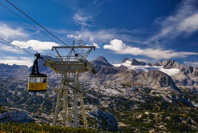 Overhead cable car on snowcapped mountains against sky