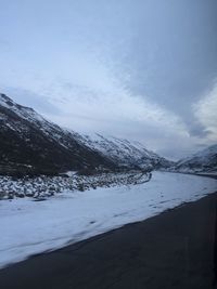 Scenic view of mountains against cloudy sky