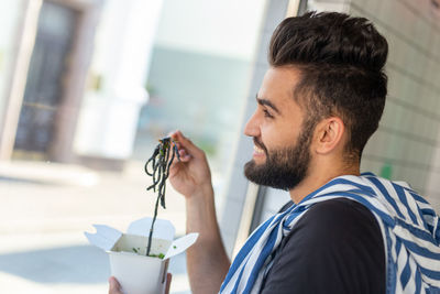 Portrait of young man drinking outdoors