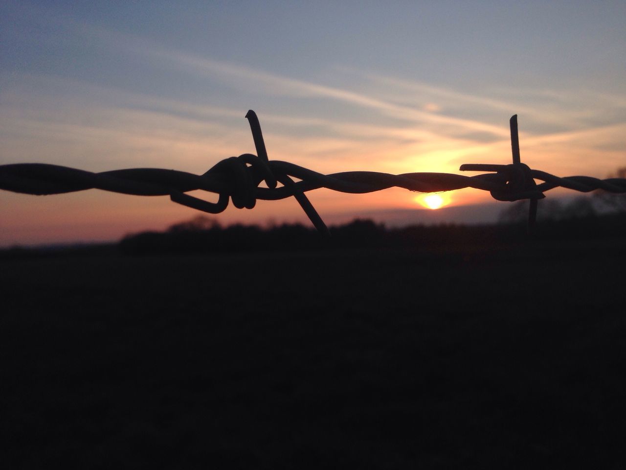 sunset, silhouette, sky, orange color, safety, metal, security, protection, fence, bicycle, cloud - sky, chain, outdoors, barbed wire, metallic, transportation, tranquility, nature, no people, dusk