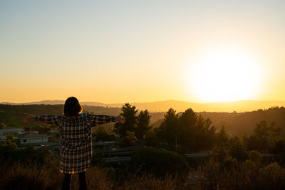 Rear view of man looking at sunset