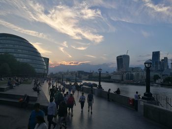 People in city against sky during sunset