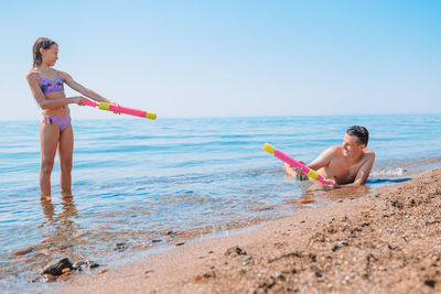 Father playing with daughter at beach