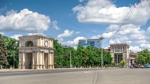 Street by buildings against sky in city