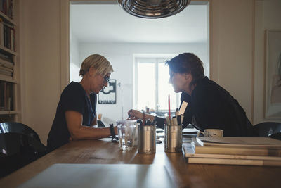 Side view of a couple sitting on table