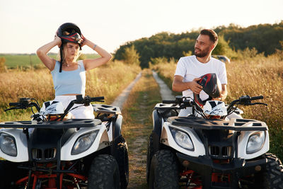 Side view of man riding motor scooter on road