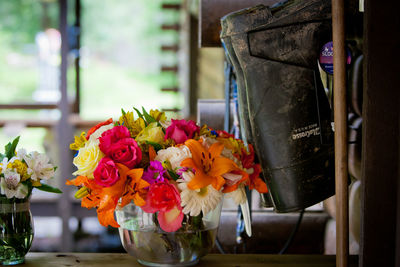 Colorful flowers in vases by rubber boot