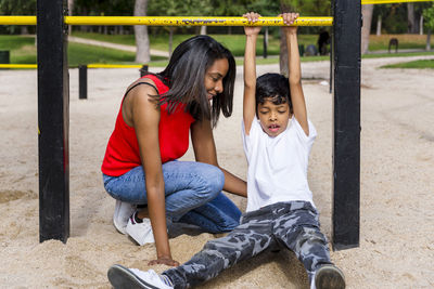Mother and son enjoying playing at the playground in the park.