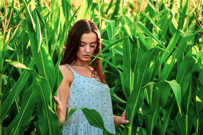 Young woman standing amidst plants