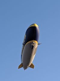 Low angle view of airplane against clear blue sky