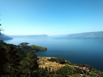 Scenic view of lake against clear blue sky