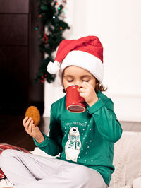 Cute girl drinking hot chocolate with cookie