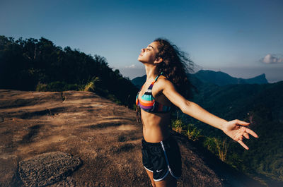 Young woman on mountain against sky