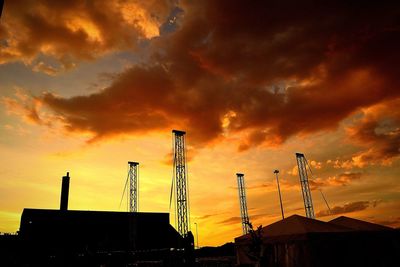 Low angle view of silhouette cranes against sky during sunset