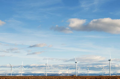 Wind turbines against blue sky on sunny day