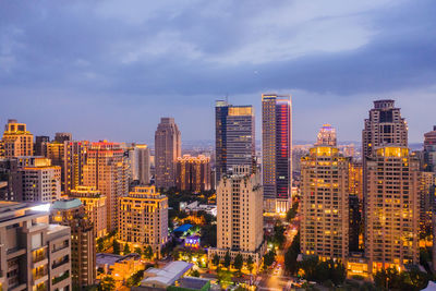 High angle view of illuminated buildings against sky in city