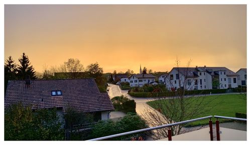 Scenic view of residential buildings against sky during sunset