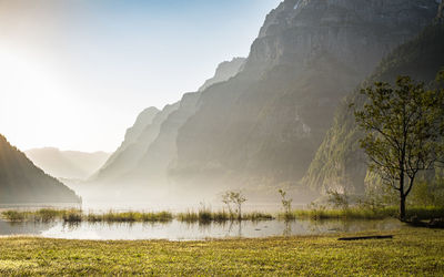 Scenic view of lake by mountains against sky