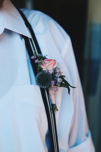 Midsection of woman holding white flowering plant