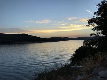 Scenic view of lake against sky at sunset