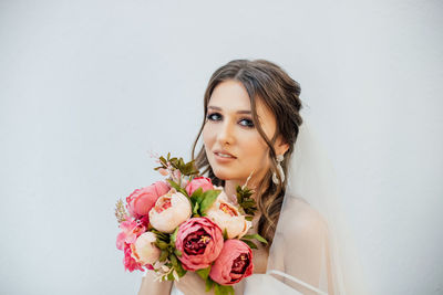 Portrait of beautiful young woman against white background