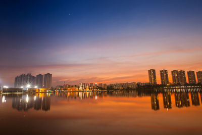 Panoramic view of illuminated buildings against sky during sunset