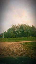 Scenic view of field against rainbow in sky