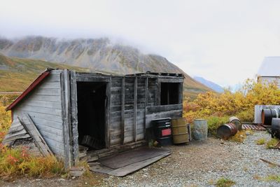 Old house by building against sky
