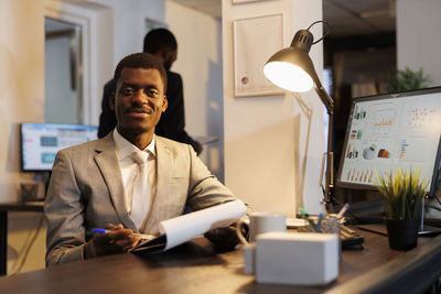 Side view of businessman using laptop at office