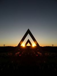 Silhouette landscape against clear sky during sunset