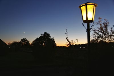 Silhouette trees against clear sky at sunset