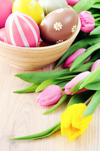 High angle view of tulips with easter eggs on table