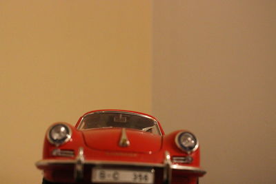 Close-up of vintage car on table against wall