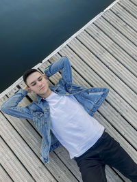 Directly above shot of man lying on pier over lake