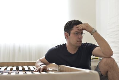 Portrait of young man sitting on table