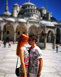 Side view of young couple standing in front of blue mosque