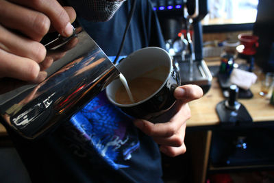 Midsection of man holding coffee cup