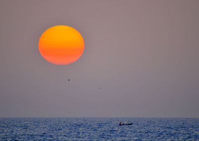 Scenic view of sea against orange sky