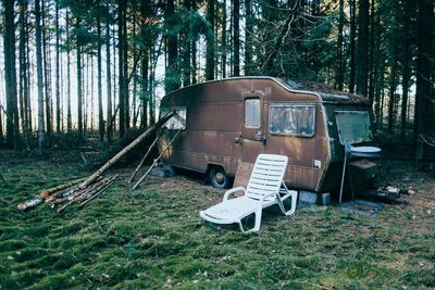 Abandoned chair on field in forest