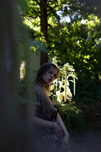 Woman standing by tree