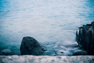 High angle view of rocks on sea shore